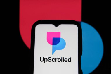 Bandung, Endonezya - 3 Şubat 2026: Bu fotoğraf ilüstrasyonlarında, UpScrolled uygulamasının logosu arka planda TikTok 'un görünür olduğu bir cep telefonunda sergilenmektedir.