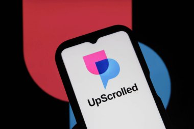 Bandung, Endonezya - 3 Şubat 2026: Bu fotoğraf ilüstrasyonlarında, UpScrolled uygulamasının logosu arka planda TikTok 'un görünür olduğu bir cep telefonunda sergilenmektedir.