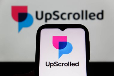 Bandung, Endonezya - 3 Şubat 2026: Bu fotoğraf ilüstrasyonlarında, UpScrolled uygulamasının logosu arka planda TikTok 'un görünür olduğu bir cep telefonunda sergilenmektedir.