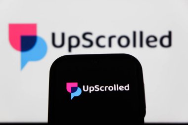 Bandung, Endonezya - 3 Şubat 2026: Bu fotoğraf ilüstrasyonlarında, UpScrolled uygulamasının logosu arka planda TikTok 'un görünür olduğu bir cep telefonunda sergilenmektedir.
