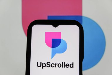 Bandung, Endonezya - 3 Şubat 2026: Bu fotoğraf ilüstrasyonlarında, UpScrolled uygulamasının logosu arka planda TikTok 'un görünür olduğu bir cep telefonunda sergilenmektedir.