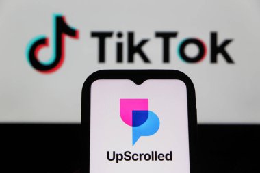 Bandung, Endonezya - 3 Şubat 2026: Bu fotoğraf ilüstrasyonlarında, UpScrolled uygulamasının logosu arka planda TikTok 'un görünür olduğu bir cep telefonunda sergilenmektedir.