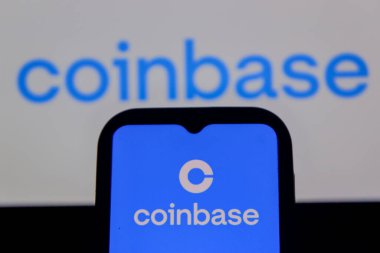 Bandung, Endonezya - 13 Şubat 2026: Bu fotoğraf ilüstrasyonlarında, Coinbase logosu bir cep telefonunda sergileniyor ve şirket markası arka planda görünüyor.