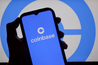 Bandung, Endonezya - 13 Şubat 2026: Bu fotoğraf ilüstrasyonlarında, Coinbase logosu bir cep telefonunda sergileniyor ve şirket markası arka planda görünüyor.