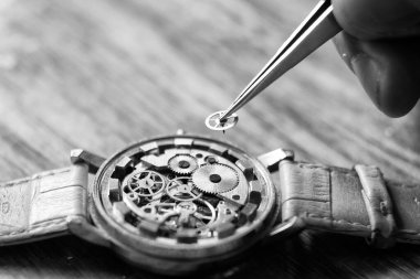 Mekanik saat tamiri. Saatçi antika mekanik saatleri tamir eder. Saatçiler atölyesi.