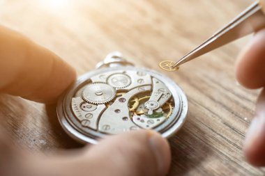 Mekanik saat tamiri. Saatçi antika mekanik saatleri tamir eder. Saatçiler atölyesi.