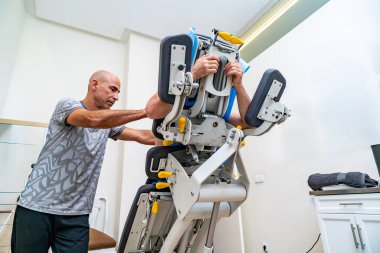 Fizyoterapist, bir klinikte pelvik zemin tedavisi için özel ekipman kullanan bir hastaya yardım ediyor.