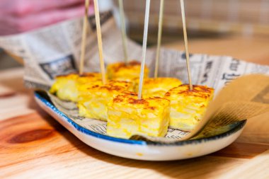 İştah açıcı küçük İspanyol tortilla parçaları servis için kürdan ile bir tabağa dizilmiş