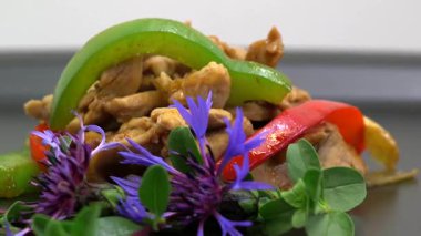 Renkli biberli kızarmış tavuk ve taze otlar.