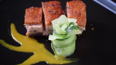 Kıtır kıtır domuz eti sunumu, taze bitkiler ve sos.