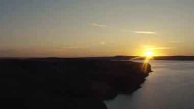 Gölün kıyısındaki sakin suların üzerinde sersemletici günbatımı manzarası