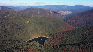 Huzurlu bir dağ gölü manzarası üzerinde canlı sonbahar renkleri