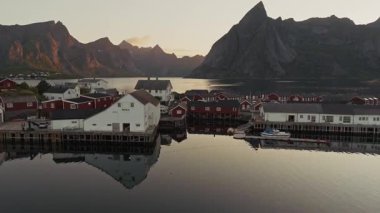 Norveç fiyortlarındaki balıkçı köyünün üzerinde çarpıcı bir gün batımı.