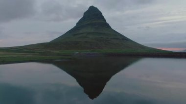 Güzel Kirkjufell Dağı alacakaranlıkta sakin suları yansıtıyor.