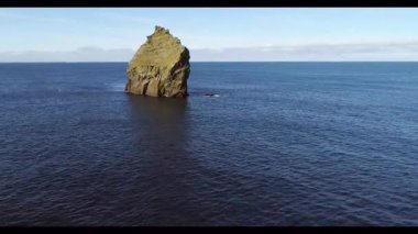 Gün batımında sakin okyanusun yanında ada kaya oluşumu