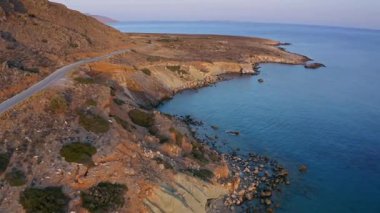 Gün batımında sakin bir sahil kenarında manzaralı bir yer.