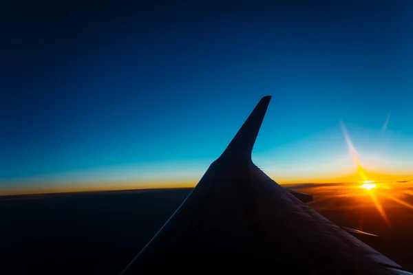 Vista do pôr do sol a partir da janela de um avião — Fotografia de Stock