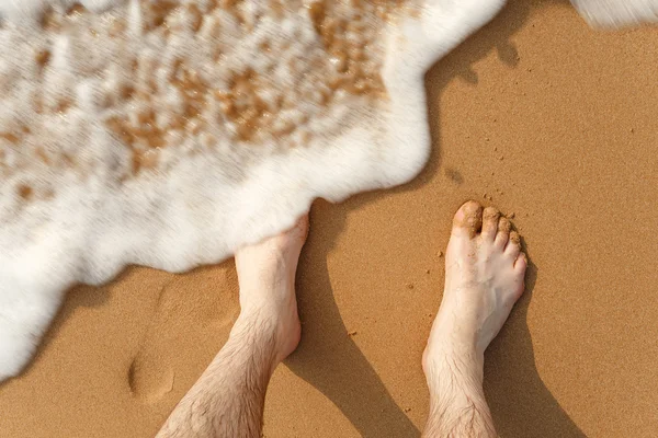 Ondas batendo contra as pernas na praia — Fotografia de Stock