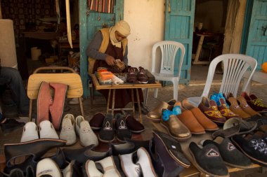 DOUZ, TUNISIA. 23 Aralık 2018 'de. Douz, Tunus 'taki pazarda ayakkabı dikmek ve satmak..