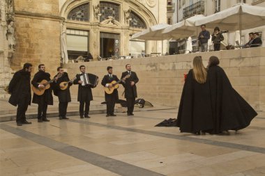 COIMBRA, PORTUGAL, 19 Nisan 2022. Portekiz 'in Coimbra şehrinde geleneksel Portekiz Fado' sunu sergileyen bir grup..