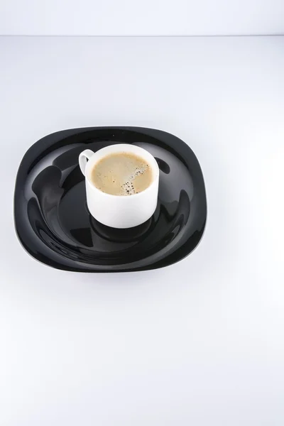 Taza de café en un plato negro — Foto de Stock