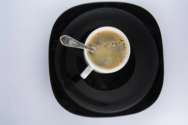 Tasse Kaffee auf einem schwarzen Teller — Stockfoto