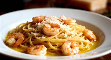 Sarımsaklı Karides Pastası. Beyaz tabakta parmesan peynirli karides sarımsaklı ve tereyağlı melek saçlı spagetti..