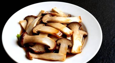 Kızarmış mantarları (Pleurotus Eryngii (Kral İstiridye Mantarı) beyaz tabakta istiridye sosuyla karıştır.