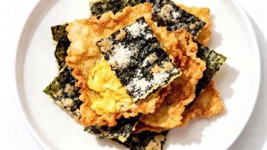 Bol yağda kızartılmış un ve yumurtalı deniz yosunu. Beyaz tabakta çerez yosunlu tempura cipsi. Üst görünüm.