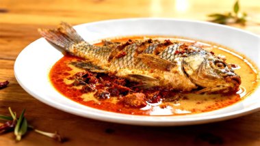 Kırmızı köri soslu balık, Tayland yemeği kurutulmuş baharatlı köri ezmesi ve hindistan cevizi sütü karışımı beyaz tabakta tırmanan gourami balığı.