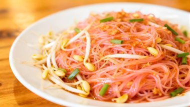 Kızarmış pirinç sosunu Yen Ta Fo sosuyla karıştır. Beyaz tabakta pembe ve ekşi pirinç eriştesi. Tayland 'ın en popüler ve iyi bilinen erişte yemekleri.