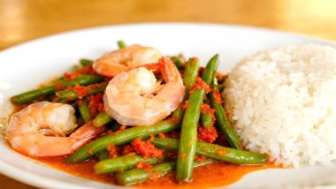 Kızarmış karides ve fasulye ile kırmızı köri ezmesini karıştırıp beyaz tabakta Tayland yasemin pilavıyla pişirdim..