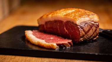 Meat Picanha bifteği siyah kesim tahtasında geleneksel Brezilya kesimi.