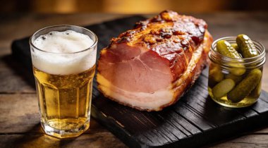 Bira ve turşu ile bir blackwooden tahtada lezzetli füme jambon