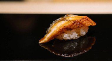 Japon deniz ürünleri suşisi nigiri ve siyah arka planda unagi.