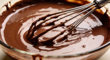 Erimiş çikolata ve çırpılmış kase, yakın plan.