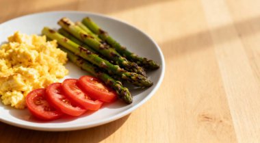 Kuşkonmaz yumurtalı ve domatesli kahvaltı.