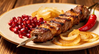 Soğanlı şiş kebap, soğan, nar, acı biber, ahşap arka plan.