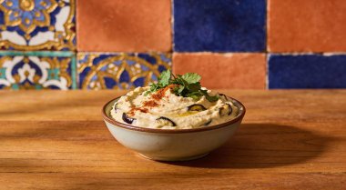 Geleneksel Arap patlıcan DIP baba ganoush otlar ve mozaik arka plan üzerinde füme kırmızı biber ile.