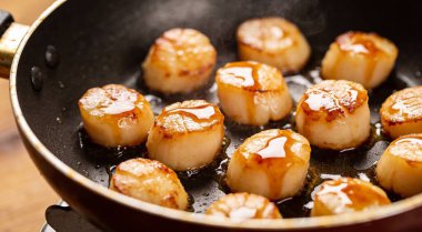 Kızartma tavasında soslu leziz istiridyeler, yakın plan.