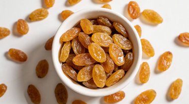 Beyaz arka planda, üstten görünüm üzümlü kase. Sağlıklı kurutulmuş meyve