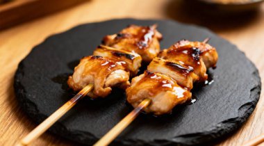 Siyah taş tabakta teriyaki soslu tavuk şişleri. Kırsal tarzda. Barbekü menüsü.