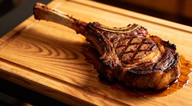 Tahta kesme tahtasında taze ızgara Tomahawk bifteği.