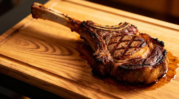 Tahta kesme tahtasında taze ızgara Tomahawk bifteği.