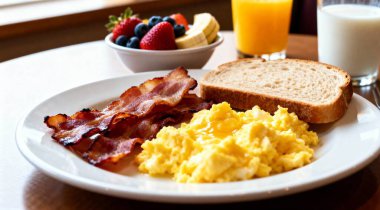 Sabah çırpılmış yumurta pastırmalı kahvaltı portakal suyu, süt meyveli ekmek ve beyaz tabak..