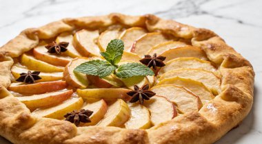 Nane ve yıldız anasonlu leziz elma galetesi beyaz mermer masada.