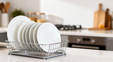Modern mutfakta temiz bulaşıklar rafta kuruyor.