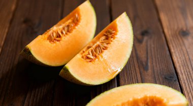 Dilimlenmiş kavun, koyu ahşap arka plan.