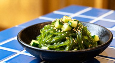 Fayanslı masada kasede servis edilen lezzetli yosun salatası.