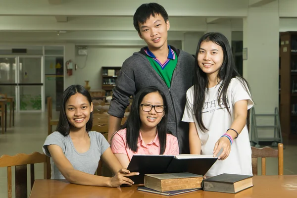 kitaplığındaki kitap okuyarak ciddi, genç bir öğrenci portresi